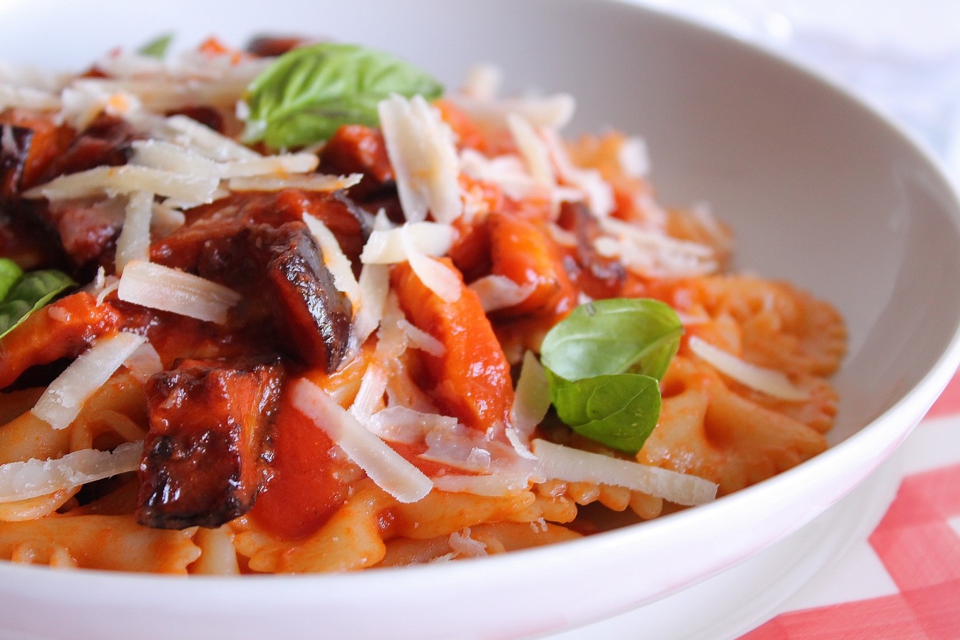 Farfalle con pomodoro, melanzane fritte, pancetta e scaglie di Grana